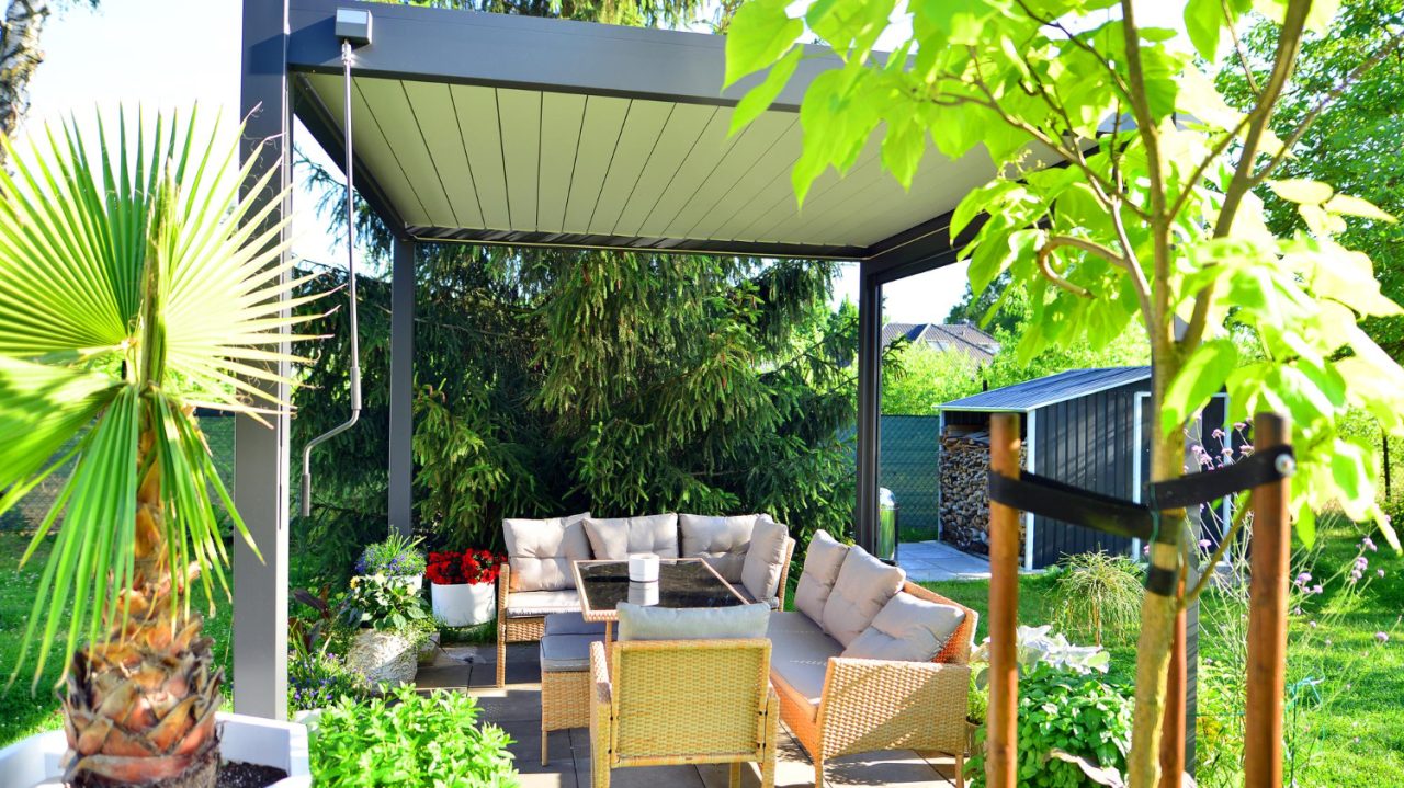 Pergola bioclimatique moderne installée sur une terrasse extérieure, mobilier contemporain dans un espace jardin idéal pour profiter des différentes dimensions et du confort extérieur.