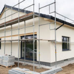 Maison contemporaine en rénovation extérieure avec échafaudage, façade isolée, nouvelles menuiseries et chantier propre.